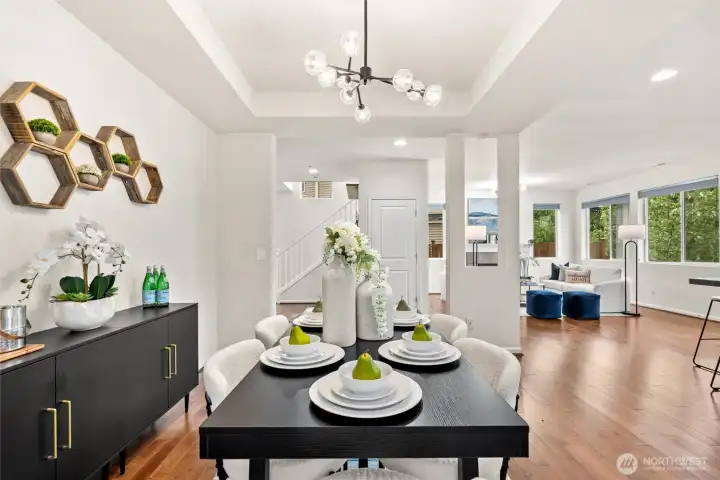 Elegant formal dining room with modern designer lighting flowing into all main spaces.