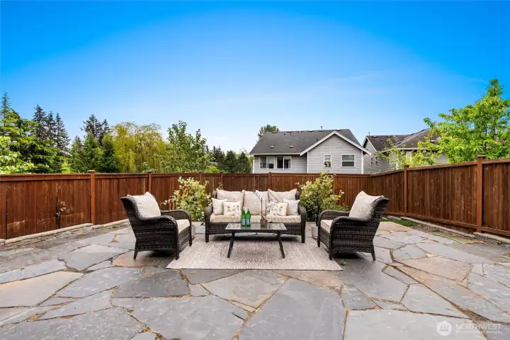 Generously sized backyard featuring a flagstone patio perfect for entertaining and relaxing.