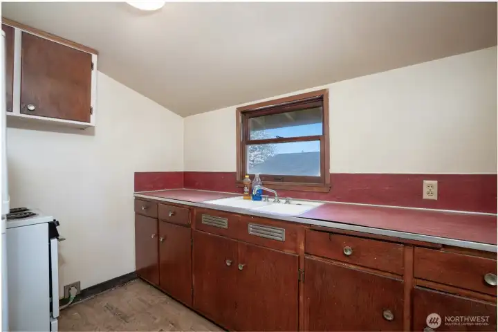 Small galley size kitchen upstairs.  Reno it and keep the home a duplex, keep it for multi-generational living, or blow out the upstairs and reconfigure to your heart's desire.