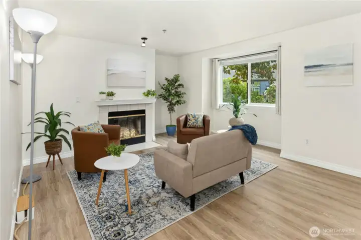 The living room has a natural, wood-burning fireplace and window to view the grassy lawn area.