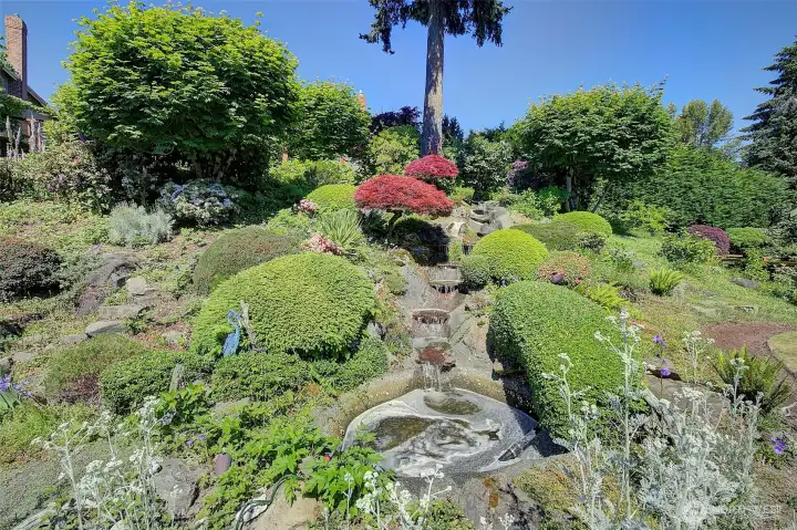 Mature landscaping with custom waterfall.