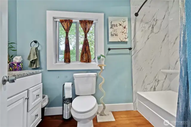 Upstairs bathroom with newer toilet & tub/shower surround w/rain shower head