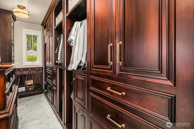 A dressing chamber with furniture grade built in cabinetry and accentuated with built in lighting.