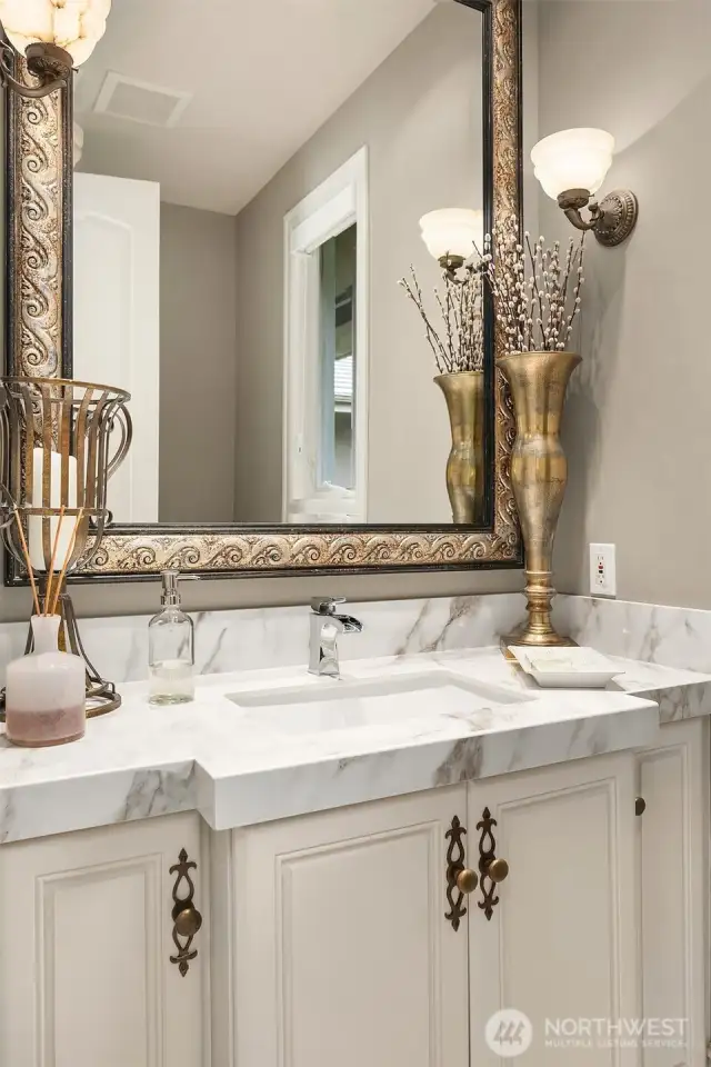 Private powder room with designer finishes and antique sconces.