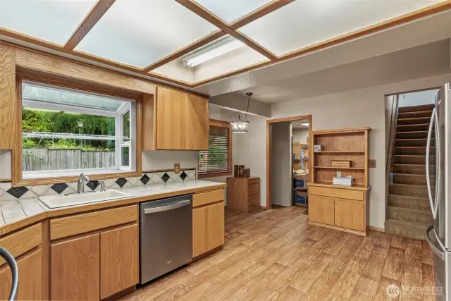 Atrium window for those favorite plants and you'll love the view of the pond and gardens out back! Exit to back deck just off kitchen. Well placed mechanic/utility room with added storage just beyond the kitchen along with stairs to level two...