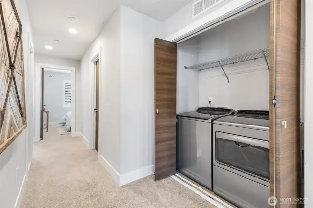Conveniently located upstairs laundry closet includes full-size washer and dryer, ventilation fan, and sliding doors