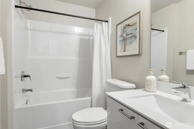 Just outside the downstairs bedroom, a full guest bathroom with tub and shower