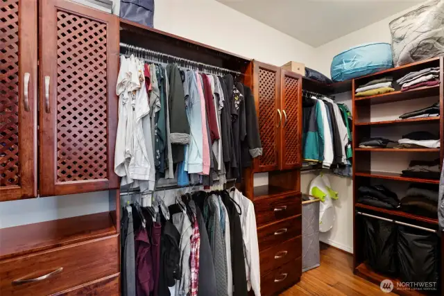 Classy solid-wood built in cabinetry in the walk-in closet keeps everything organized.