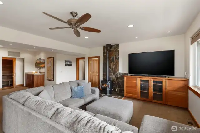 Downstairs, this huge recreation space has room for everyone, and the free-standing gas stove keeps it cozy. Two more bedrooms and baths open into the space, as well as a wet bar and sauna! The warm wood entertainment cabinets are built-in. Several roomy storage rooms, too!