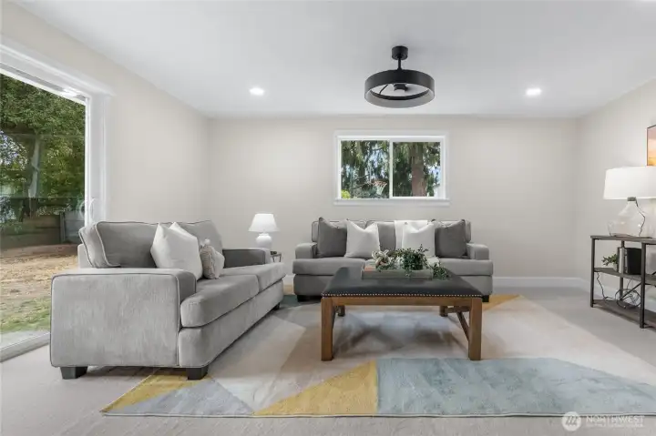 A family room off the kitchen includes new plush carpeting, paint and a stylish light black light fixture to match the black door hardware seen throughout the home.