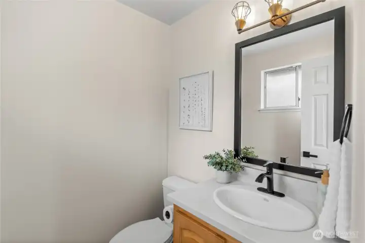 The thoughtfully placed powder room off the kitchen enhances convenience while preserving the privacy of the main bathroom.