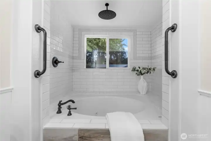 Enjoy a spa-like setting where you can unwind with a hot soaking bath or refresh with a quick shower—either way, you'll appreciate the custom white tile and sleek black hardware.