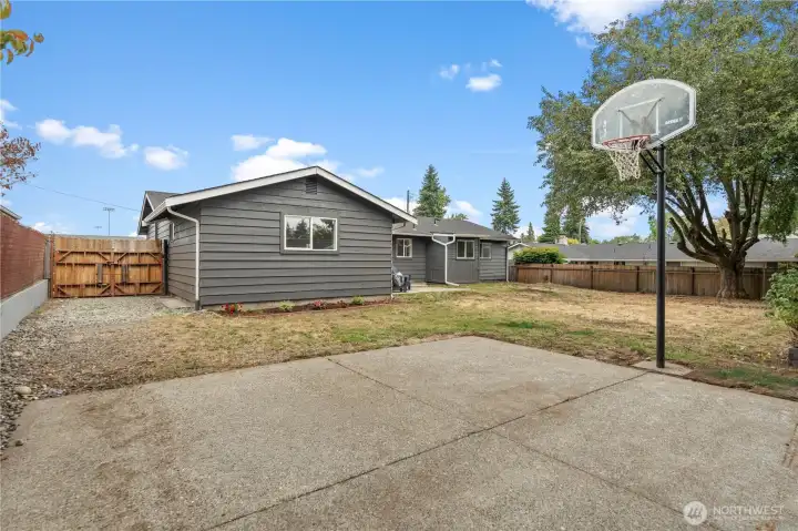 A gated entry to the backyard provides the option to securely store larger items or even a vehicle, all enclosed within the fenced yard.