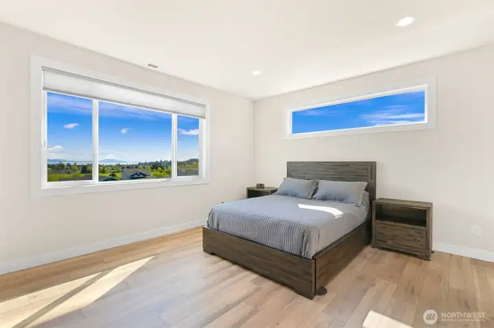 Relaxing owner's suite with warm flooring and expansive windows.