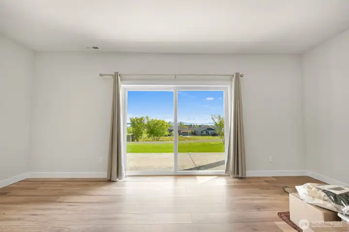 Expansive ground floor flex space with abundant natural light and walk out access, perfect for a recreation room, studio or additional living area.