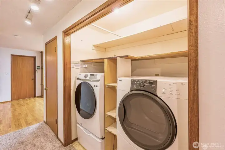 Full-size washer and dryer in the hall on the way to the bedrooms. Door on the left goes to the converted garage area with 2nd bathroom.