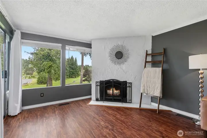 Large windows fill the living area with natural light while showcasing scenic views of the surrounding landscape.