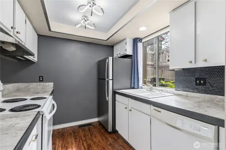 Efficient kitchen offers ample cabinetry, generous counter space, and a window overlooking the private courtyard.