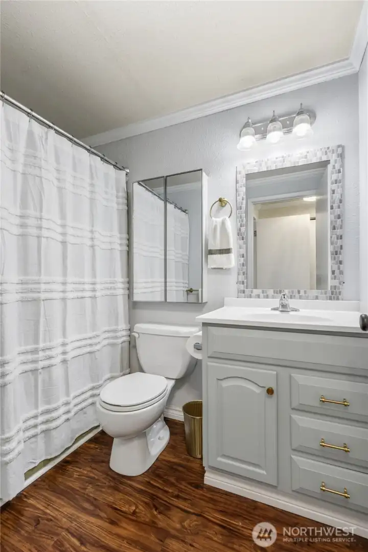 Updated bathroom off primary bedroom features modern finishes, refreshed cabinetry, and additional storage.