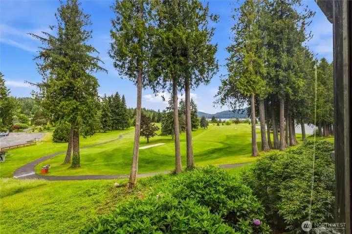 Sweeping golf course, lake, and mountain views from the primary bedroom.