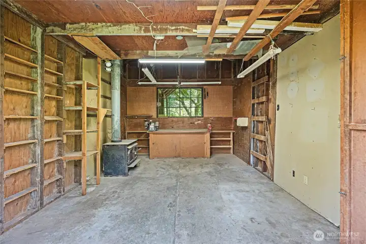 Workshop inside barn with a wood stove and concrete floor