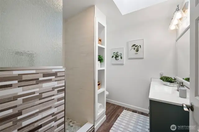 Beautifully updated primary bath with tiled walk-in shower and a skylight