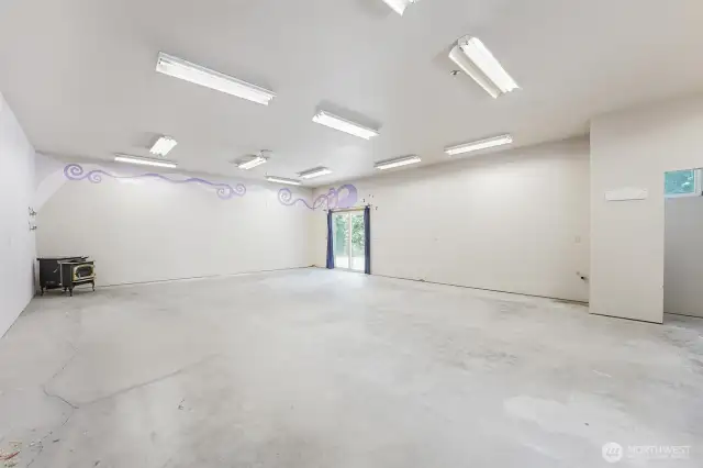 Insulated hobby room with sliding glass doors to its own patio.  220 outlets, a 440 outlet, pellet stove and rough plumbed for a bathroom.