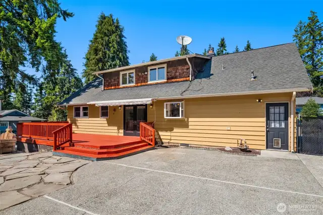 Back of property features flagstone and spacious deck for gatherings.