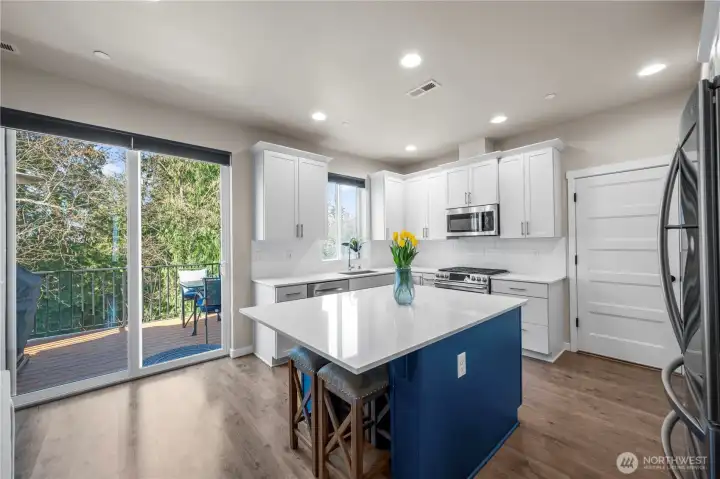 Designer kitchen with quartz counters, tile backsplash, and stainless appliances.