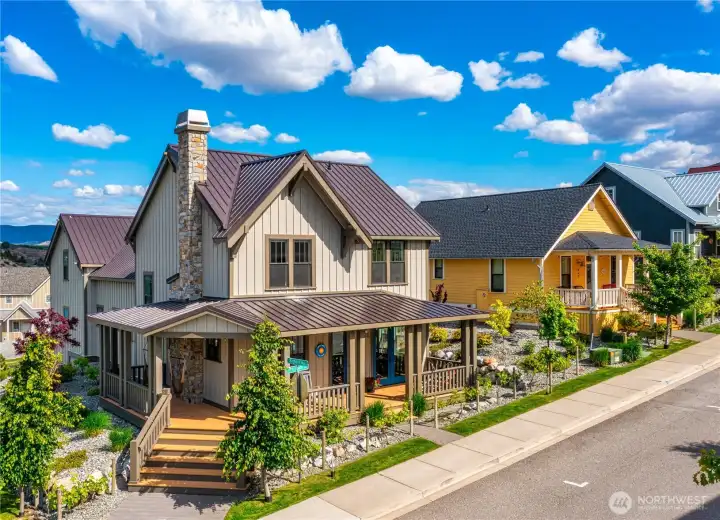 Exterior view of home on corner homesite with classic covered front porch and landscaping.