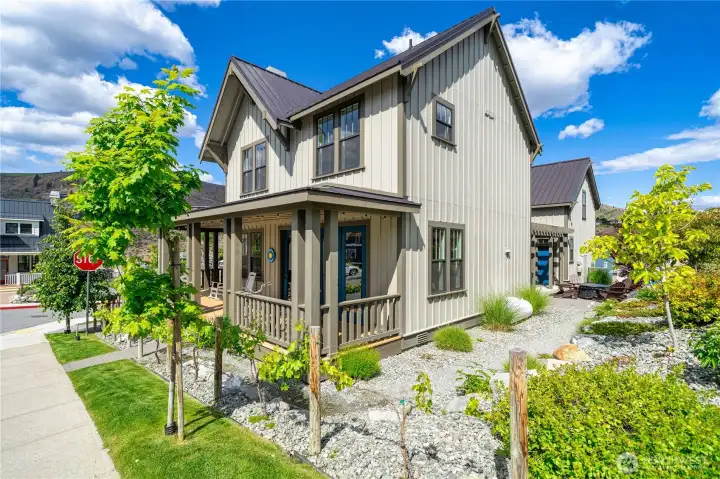 Exterior side view of home with classic covered front porch and landscaping.