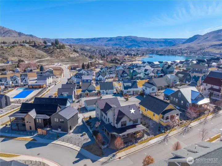 Aerial view of home looking west towards downtown Chelan with the heated year-round Vineyard District pool to the left.