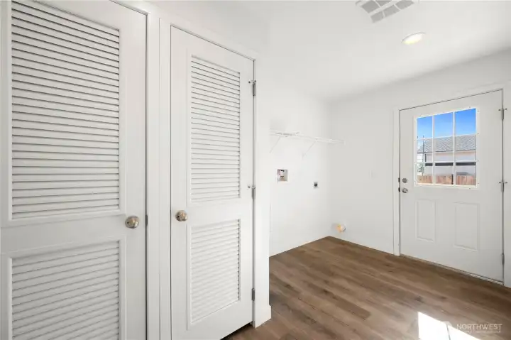 Large utility room with door leading to deck and backyard
