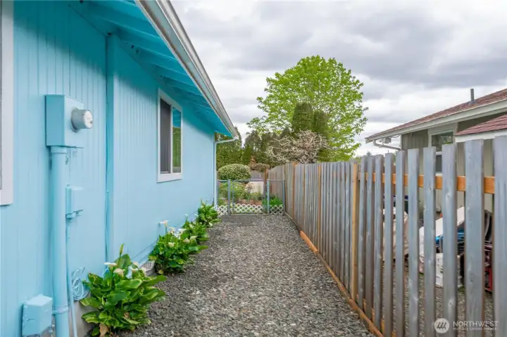 Private fenced dog run with gated access and low-maintenance gravel surface.