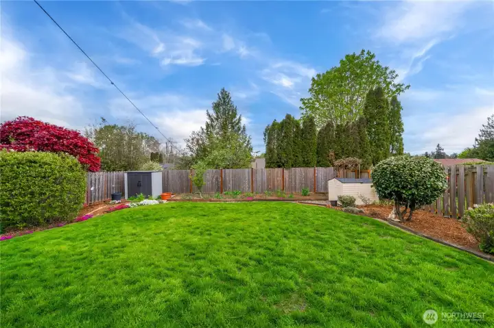 Private backyard oasis with vegetable garden, grape vine, and blooming flower beds