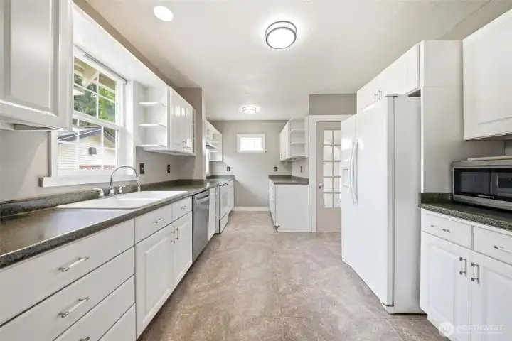 Large kitchen features ample cabinetry, counter space, and a door down to the basement.
