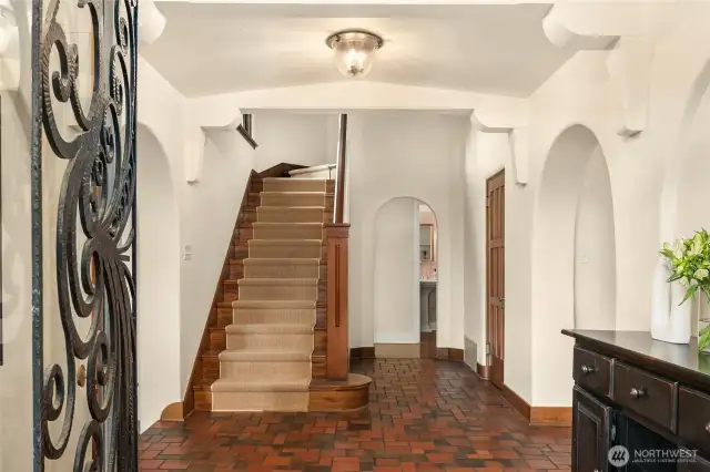 Central front hall, with a tile floor and a nod to perhaps a bit of a Santa Barbara feel in all those arches!