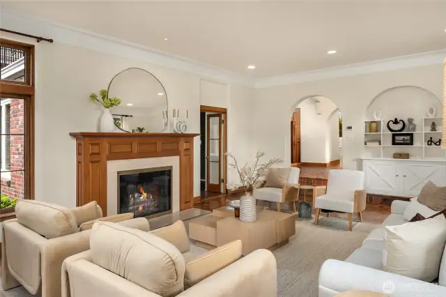 In this photo you can see how the living room sits down front he central hall.  The door you see open next to the fireplace leads to a cozy den or office.