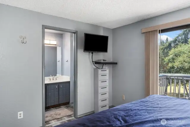 Primary bedroom has sliding glass doors to a quaint deck.