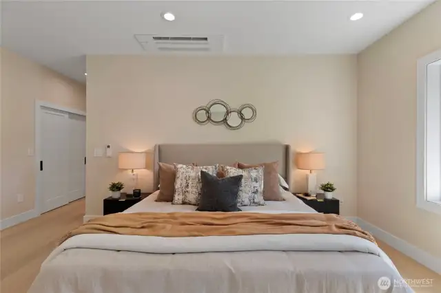 Luxurious primary bedroom featuring generous storage, refined finishes, and sweeping cielings that enhance the sense of space.