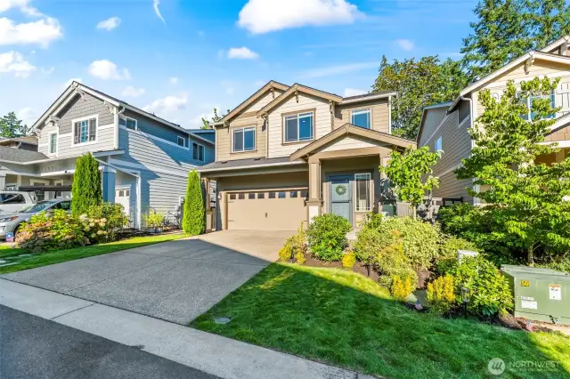 Another angle of the front elevation highlighting the welcoming driveway, manicured landscaping, and impressive architecture of this Black Diamond home for sale.