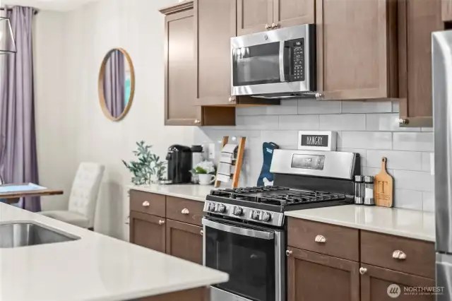 Gourmet kitchen featuring stainless steel appliances, quartz countertops, and modern cabinetry.