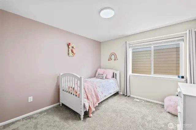 Secondary bedroom with soft tones and large window – perfect for guests or family.