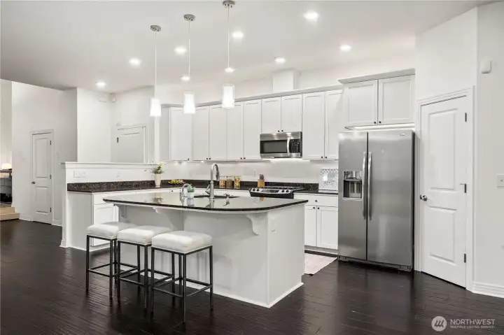 The gourmet kitchen features granite countertops, a statement island, & rich repainted cherry cabinetry