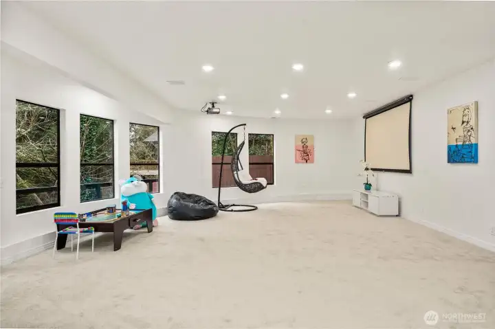 Oversized bonus room downstairs with a projector and screen