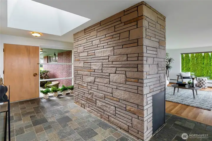 The large stone fireplace creates a dramatic focal point and grounds the main level with warmth and authenticity.