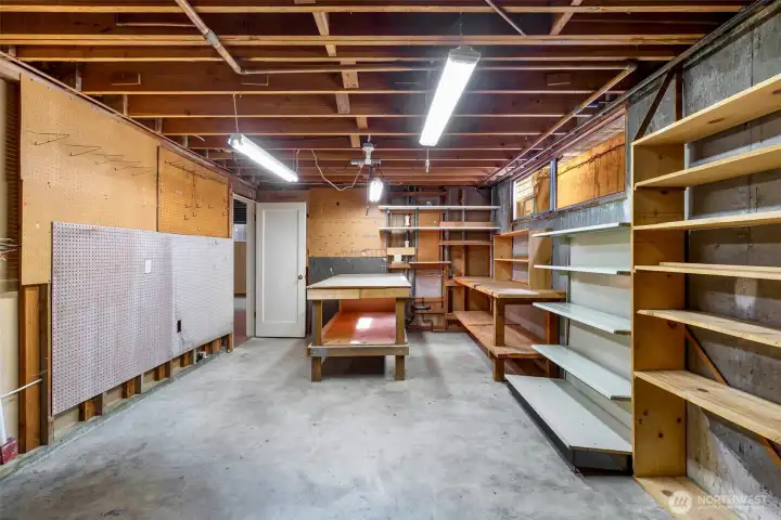 This basement workspace connects to the two-car garage via an internal back staircase — practical, functional, and full of possibility.