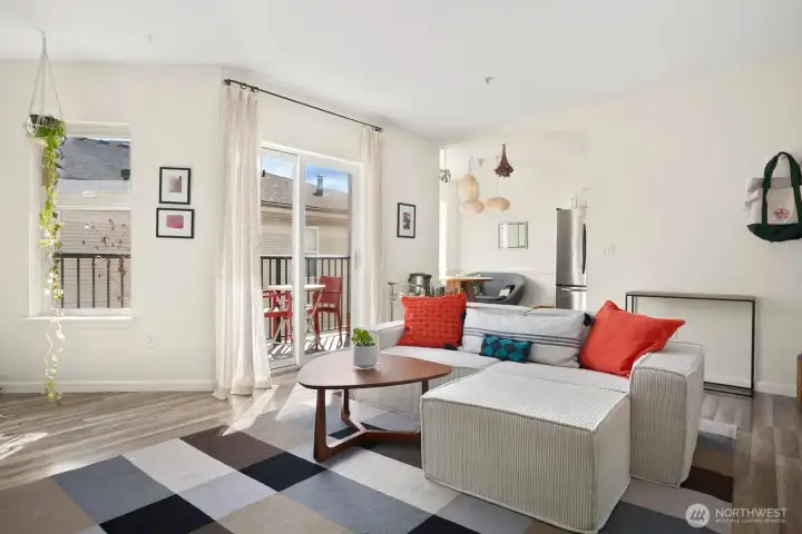 Living room looking to dining nook and sliding glass door leading to balcony