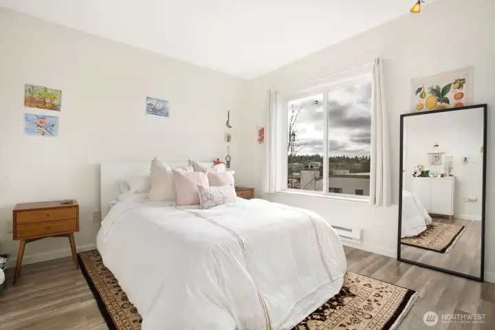 Primary bedroom with large window, natural light