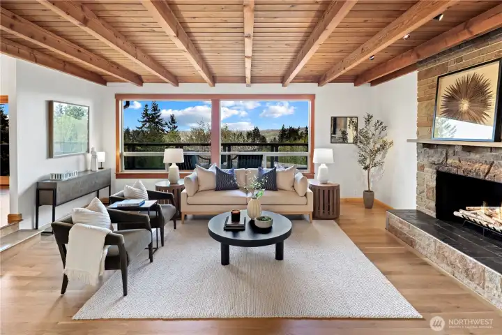 Sunken living room and picture windows will pull you right into the center of the home. Real stone fireplace with raised hearth, and warm wood beams. All new oak hardwood flooring in the entry, living room, dining room, and kitchen to tie into the original wood floors in the bedrooms.